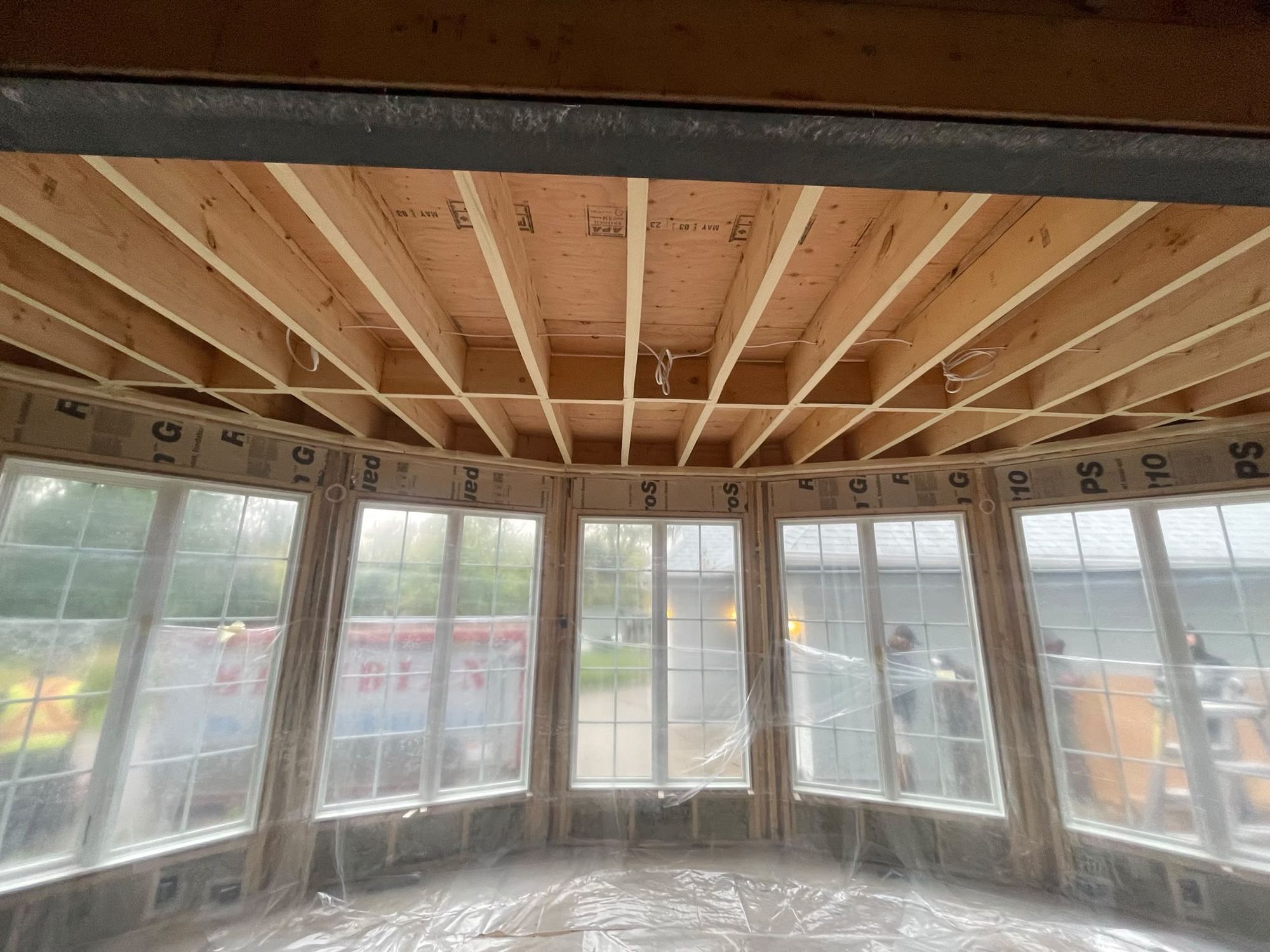 Sunroom addition with a steel beam ceiling fully spray foamed, large bay windows on three sides