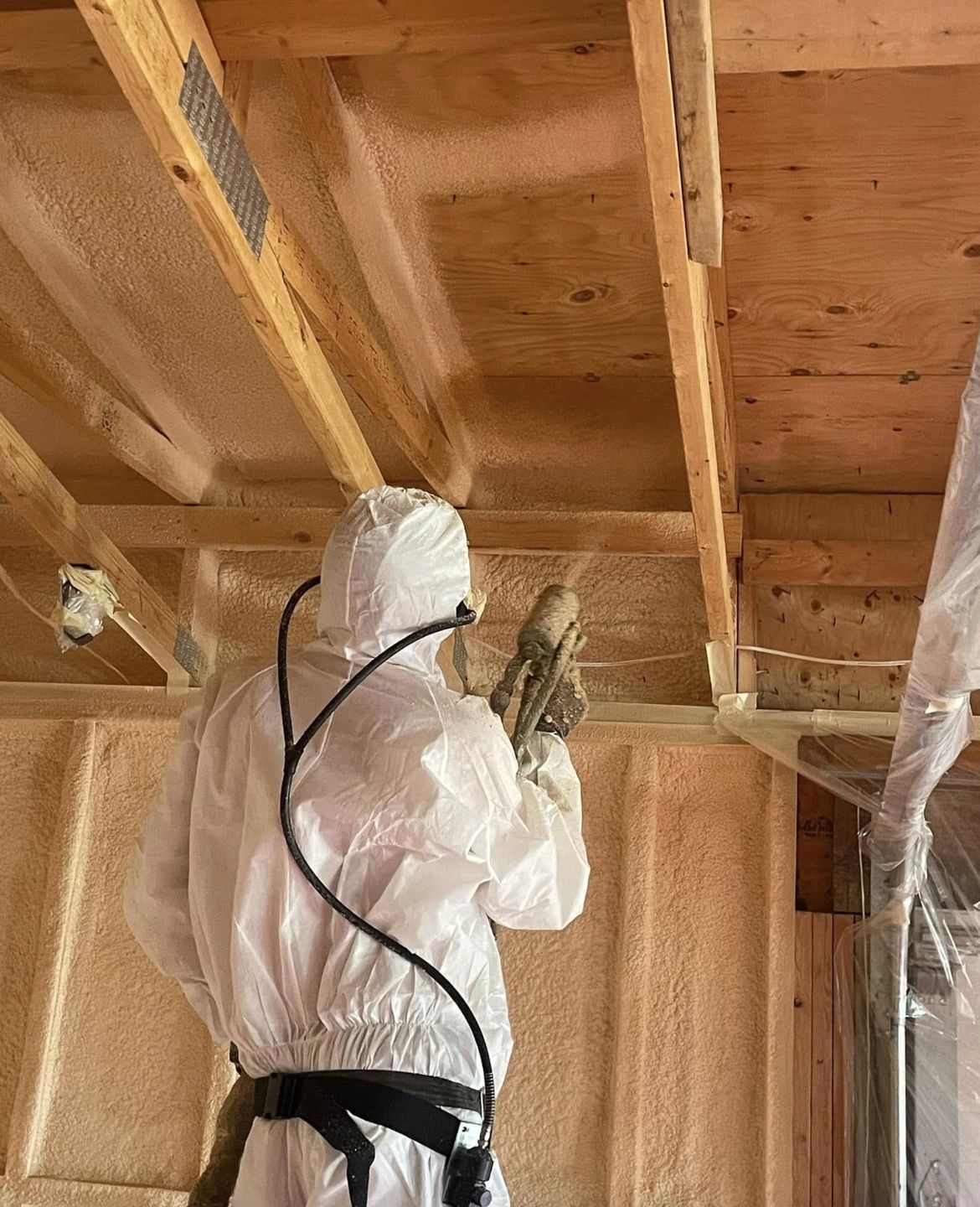 Spray foam being applied at the junction where a wall meets the ceiling